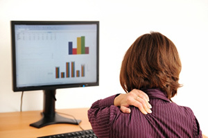 Αυχενική οστεοχόνδρωση σε μια γυναίκα που κάθεται σε έναν υπολογιστή